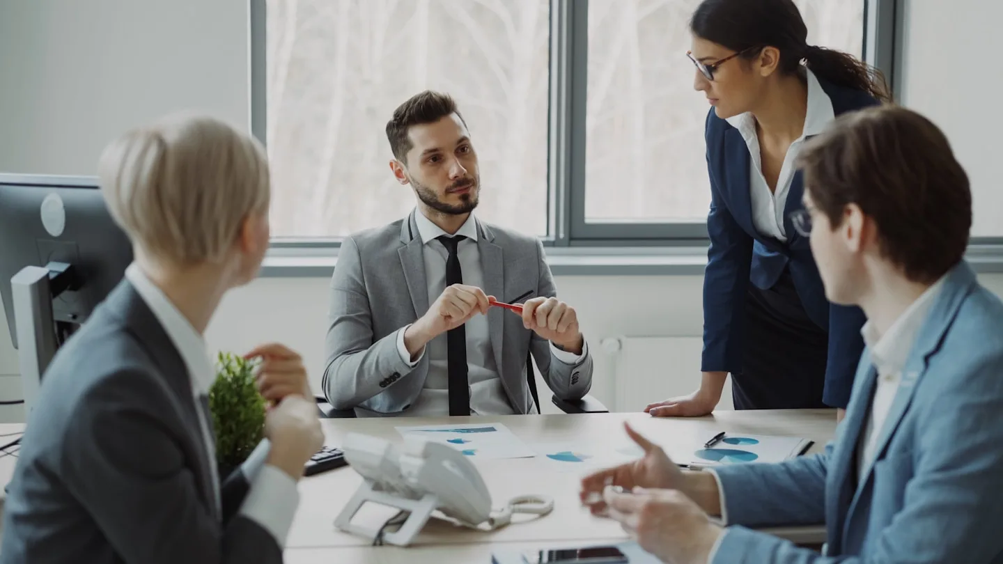 Colleagues discussing documents around a conference table